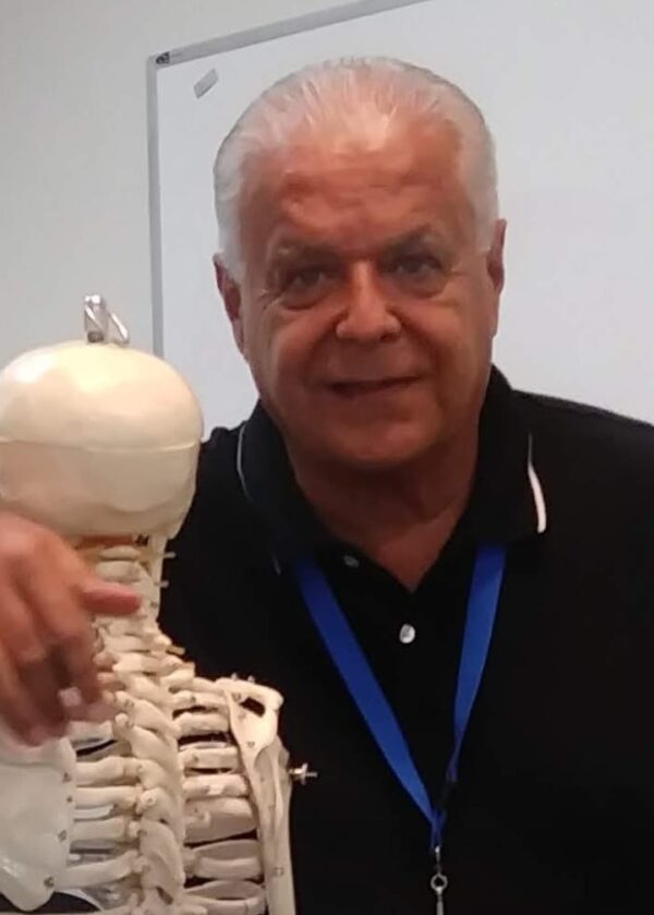 A man holding up a skeleton model in front of him.